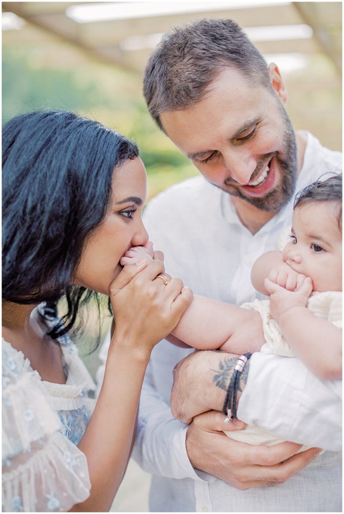 Mother Kisses Her Infant Daughter On The Feet During Montgomery County Family Session At Brookside Gardens.