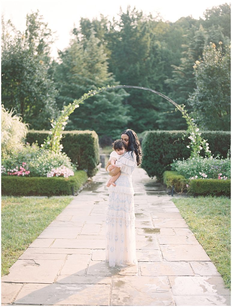 Mother Holds Her Daughter Near Floral Arch At Brookside Gardens.