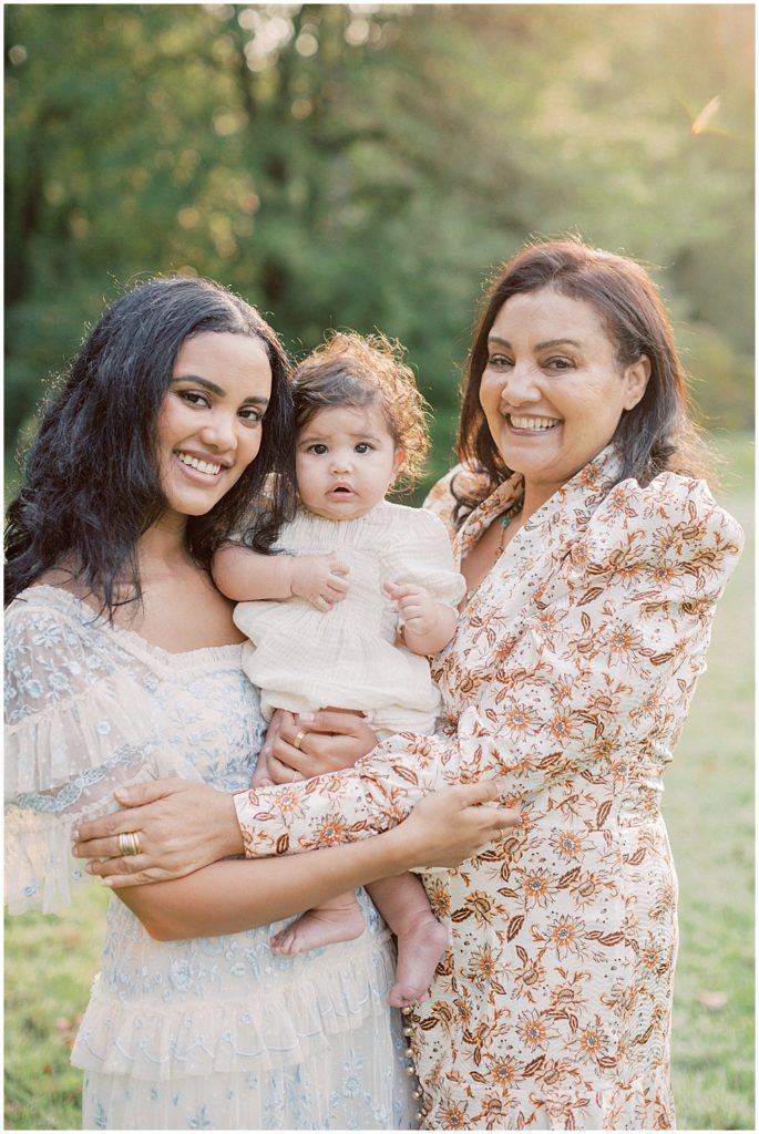 Mother, Grandmother, And Baby Girl Smile During Montgomery County Family Session At Brookside Gardens.