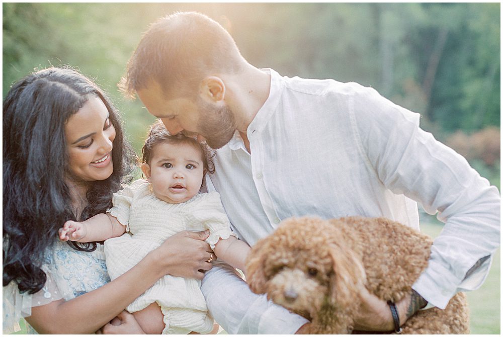 Father Kisses Baby Girl On Head During Montgomery County Family Session At Brookside Gardens.