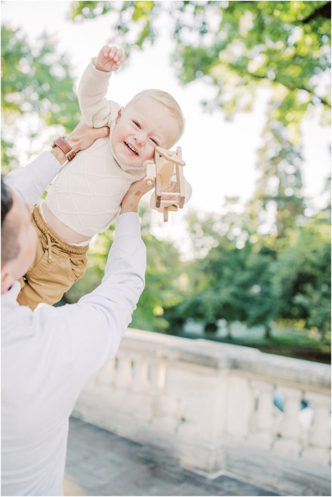 Little Boy Laughs As Father Throws Him Up In The Air.