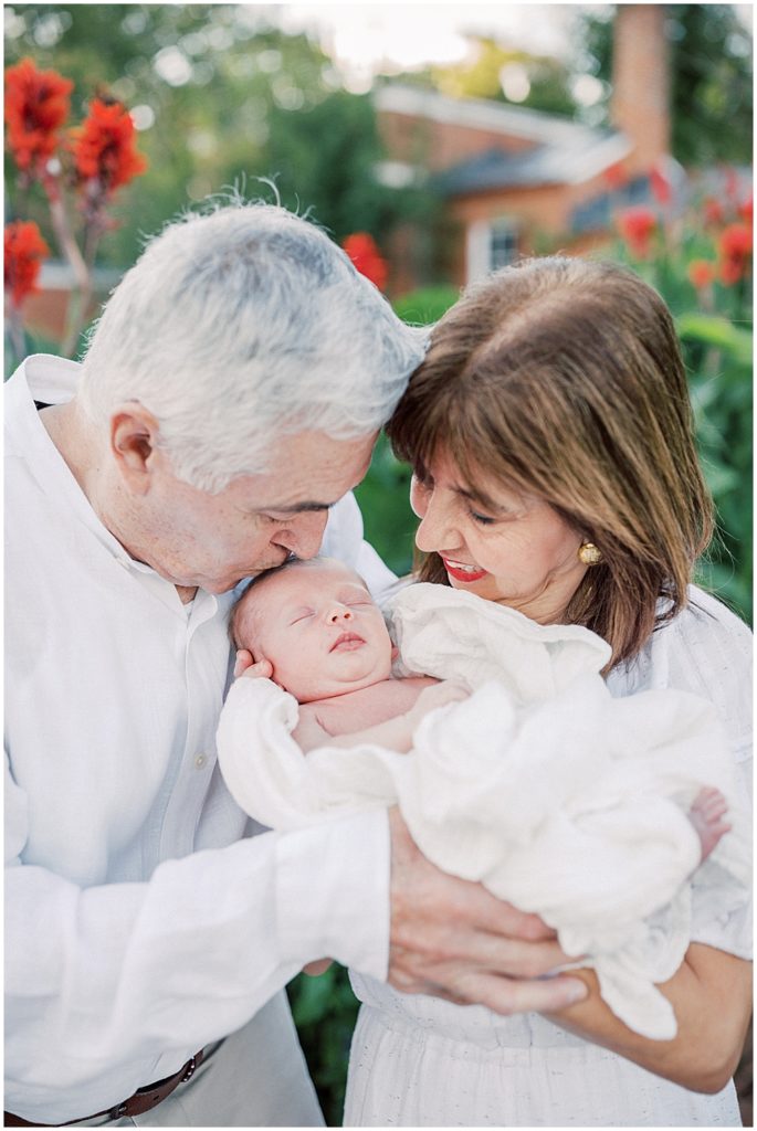 Grandfather Leans Down And Kisses Grandson.