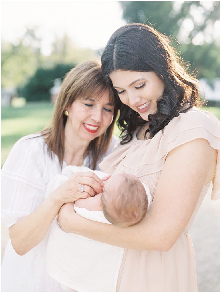 Mother Holds Her Newborn Baby While Leaning Into Her Mother.