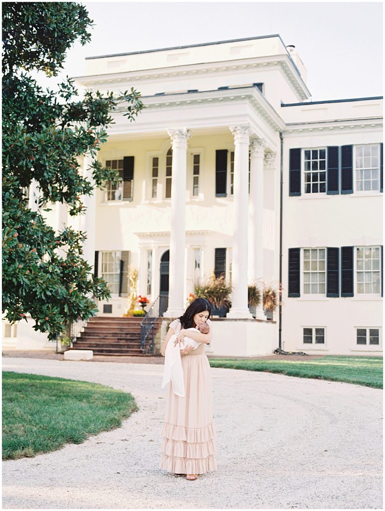 New Mother Stands In Front Of Oatlands House, Kissing Her Newborn Baby Boy.