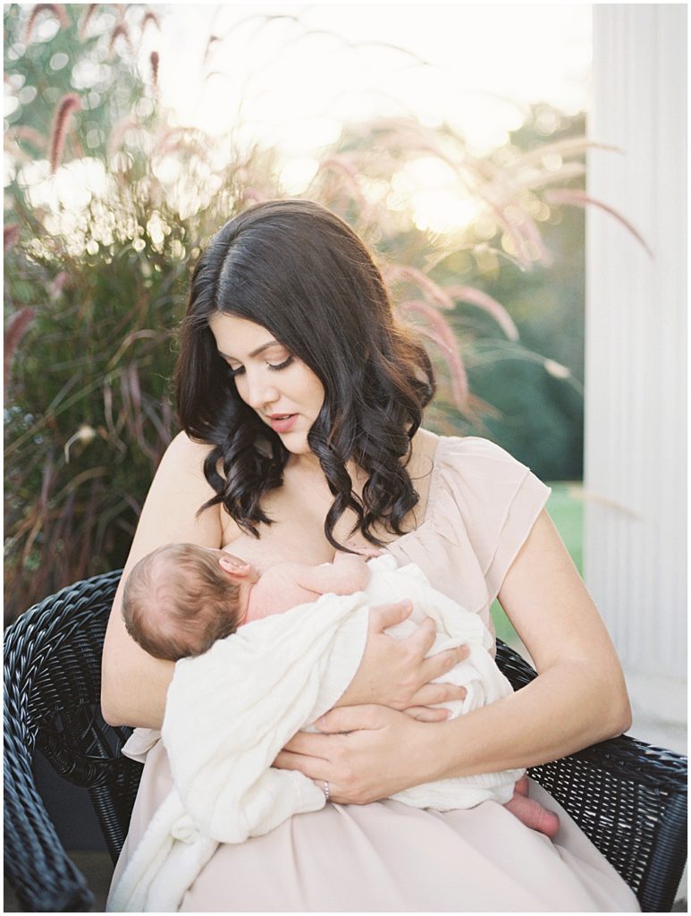 Mother Nurses Her Newborn Baby While Sitting On Porch Of Oatlands Historic Home During Newborn Session By Loudoun County Newborn Photographer Marie Elizabeth Photography.