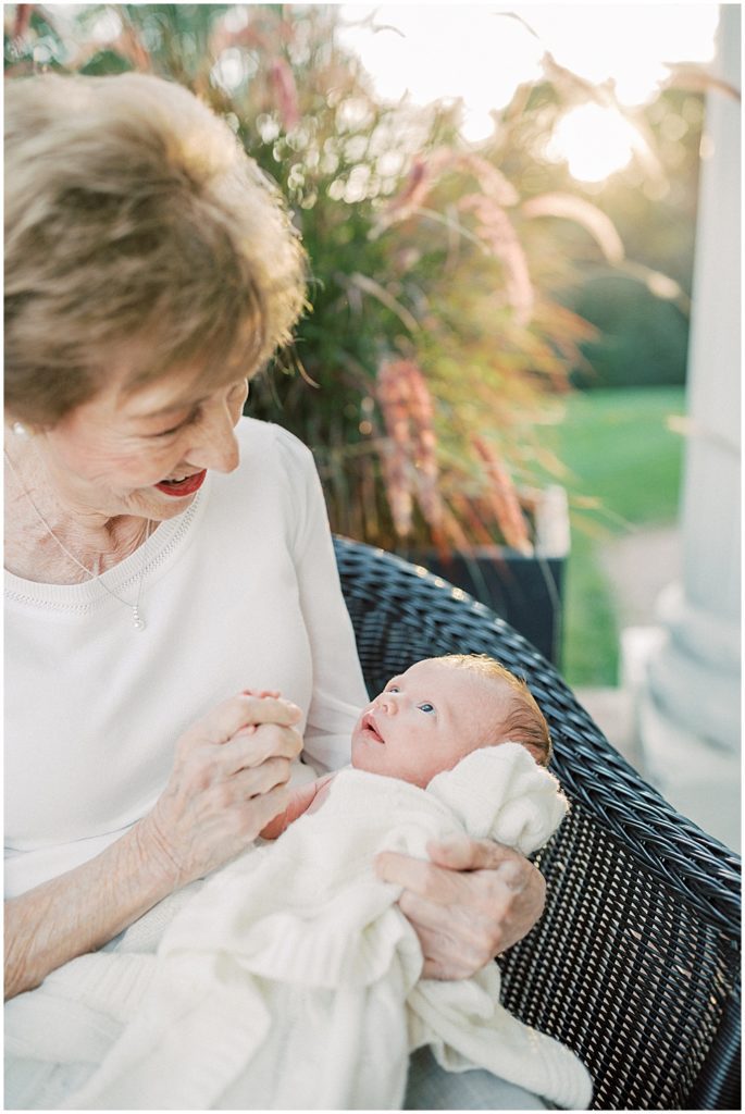 Great-Grandmother Smiles Down At Her Grandson During Newborn Session By Loudoun County Newborn Photographer Marie Elizabeth Photography.