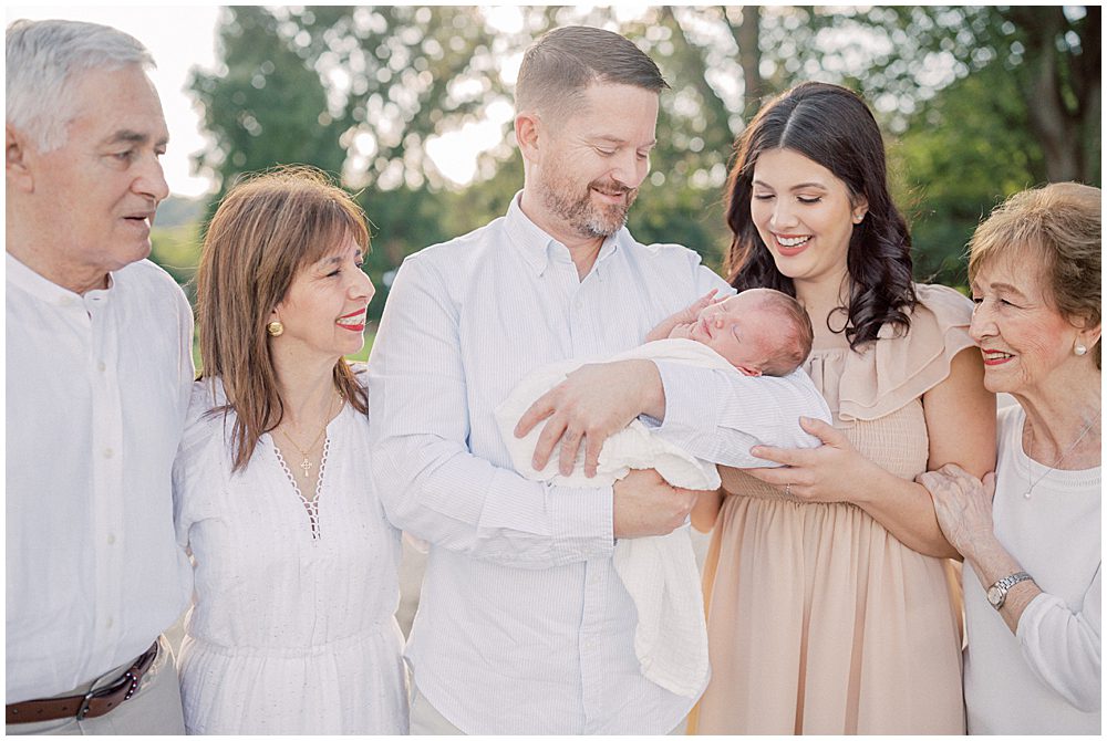 Family Gather Around Newborn Baby During Newborn Session By Loudoun County Newborn Photographer Marie Elizabeth Photography.