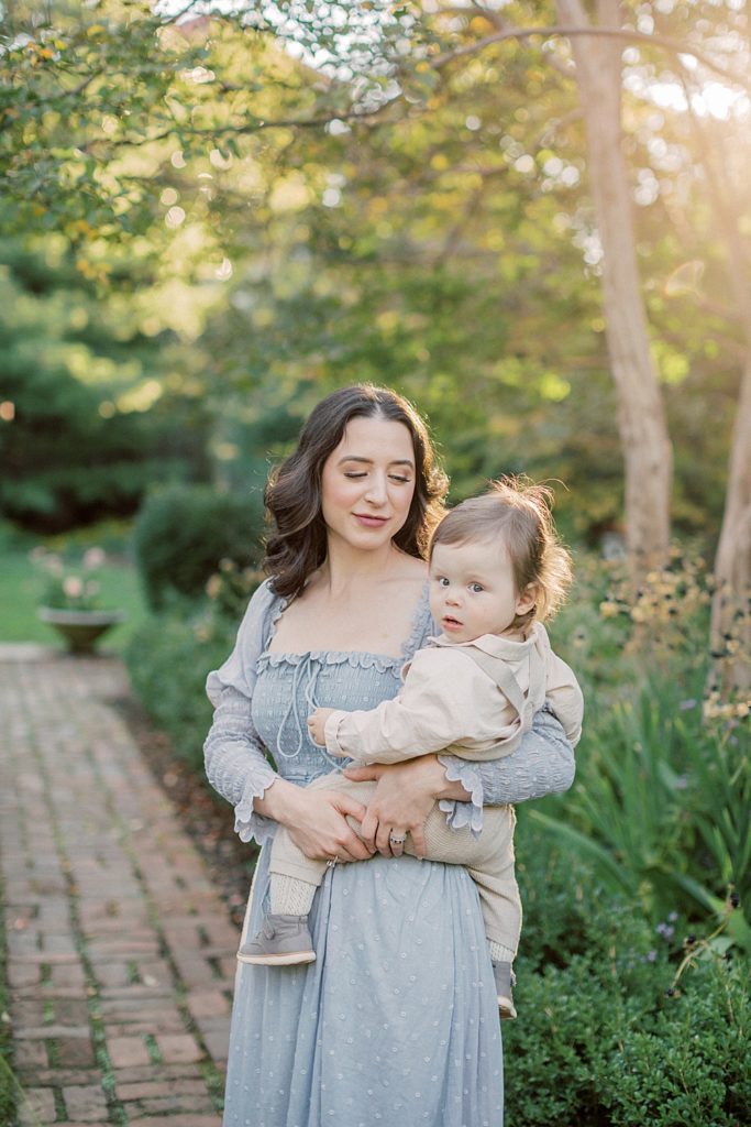 Mother In Blue Doen Dress Holds Baby Boy Down Brick Lane Photographed By Georgetown Family Photographer Marie Elizabeth Photography.