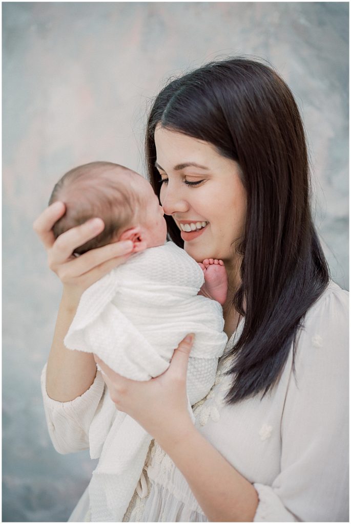 Mama Nuzzles Her Newborn Baby's Nose During Studio Newborn Session.