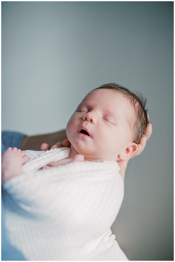 Baby Girl Is Held Out In Front Of Her Father.