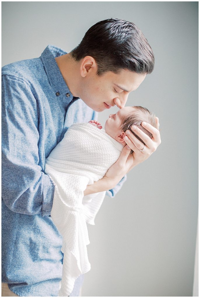 Father Brings Newborn Daughter Up To Nuzzle During Fairfax Va Newborn Session.