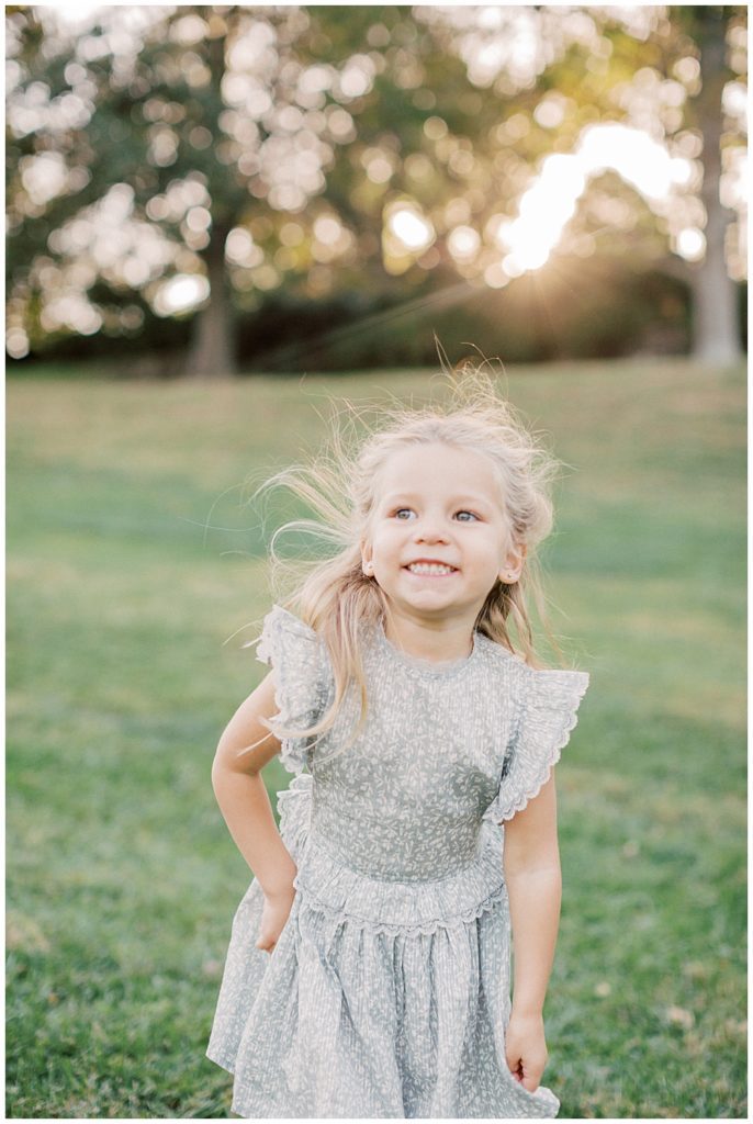 Toddler Daughter Smiles While Dancing Outside.