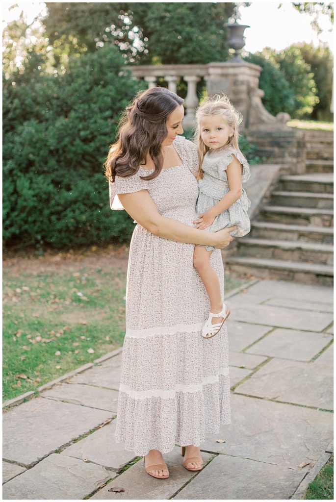 Mother Holds Toddler Daughter On Stone Pathway During Glenview Mansion Photos By Marie Elizabeth Photography.