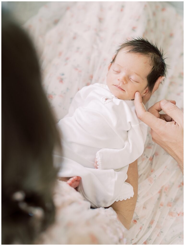 Baby Girl Held By Her Mother Is Stroked With A Finger Of Her Father.