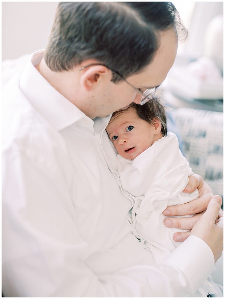 Baby Girl Lays On Her Father's Chest As He Kisses Her Head.