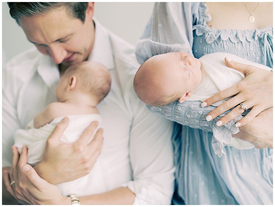 Twin Babies Are Held By Their Parents, Photographed By Newborn Photographer Marie Elizabeth Photography.