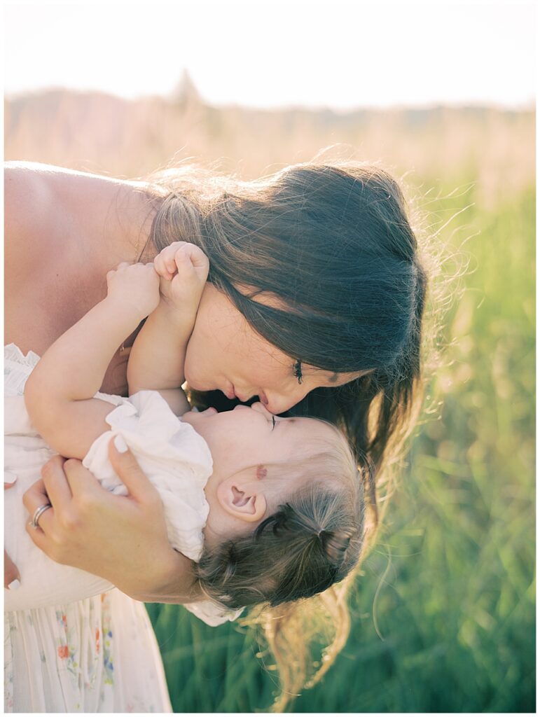 Mother Holds Her Toddler Daughter, Leaning Down With Her.