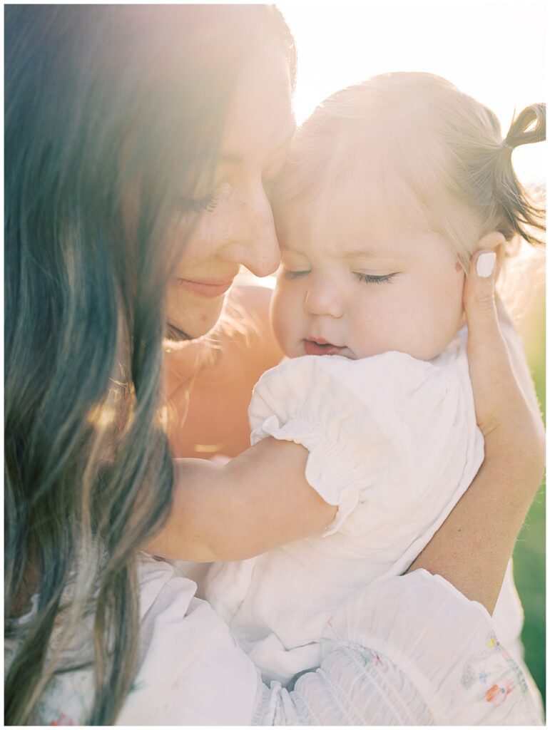 Close-Up View Of Mother Leaning Into Toddler Daughter At Sunset During Manassas Battlefield Family Session.