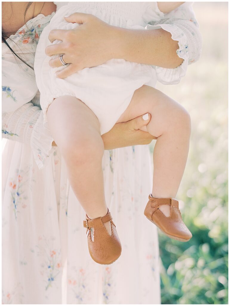 Close-Up View Of Chunky Baby Legs Held By Mother.