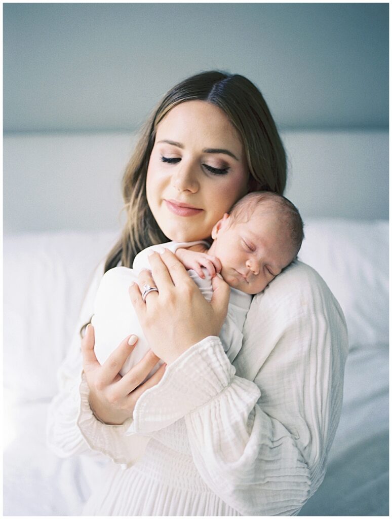 Mother Smiles Softly As She Holds Her Baby Girl On Her Shoulder During Her North Bethesda Newborn Session.