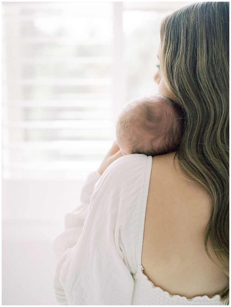 Baby's Head Rests On Mother's Shoulder.