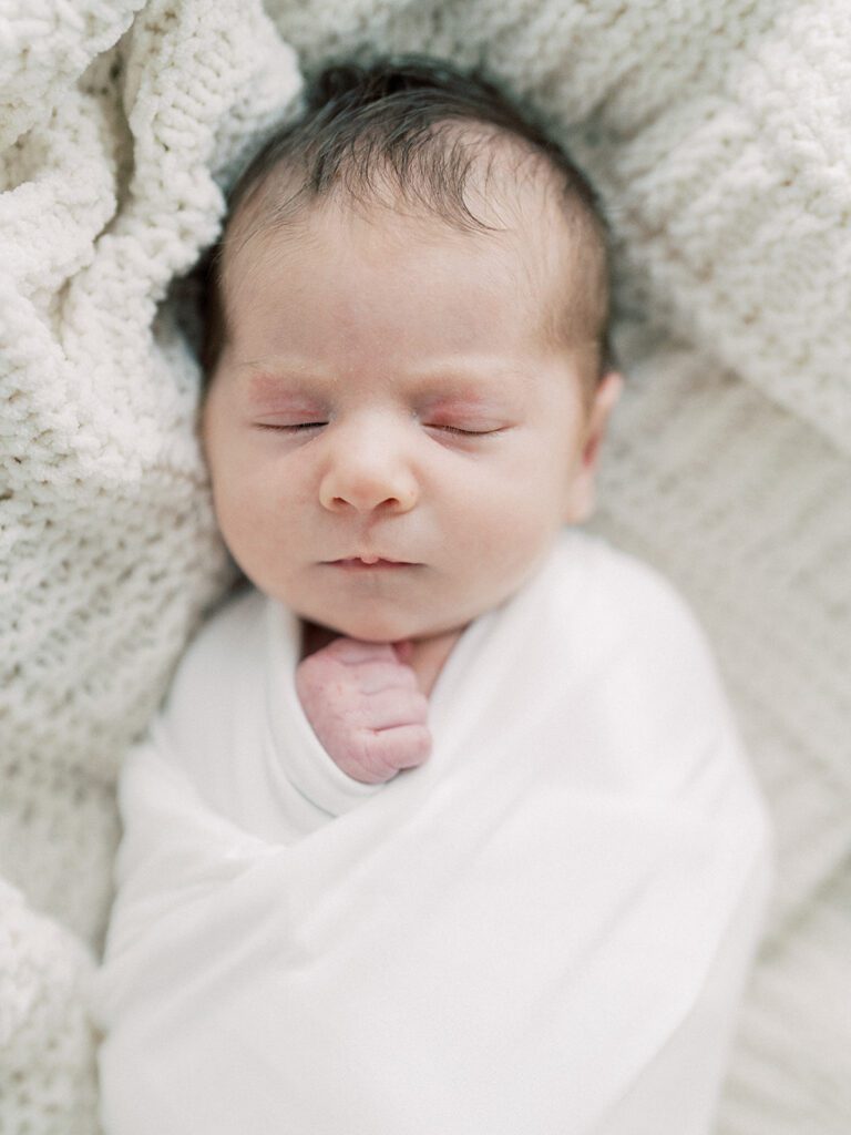 Close-Up View Of Baby Swaddled In White.