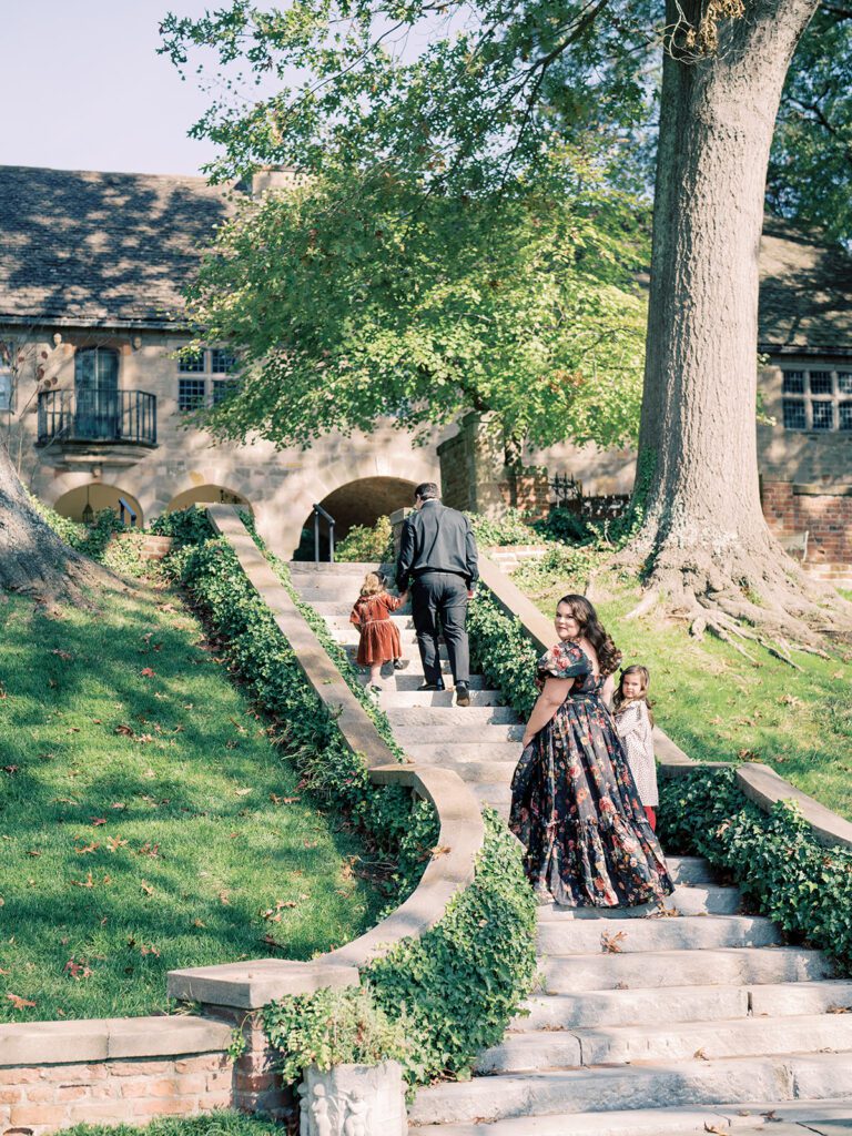 Family of four walking stone staircase outside of the Virginia House during a Virginia House family session in Richmond, VA.