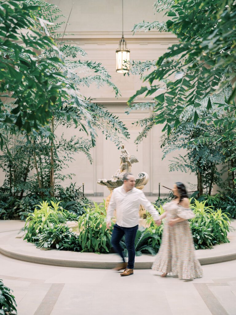 Husband And Wife Walk Together Holding Hands, Slightly Blurry, In The National Gallery Of Art.