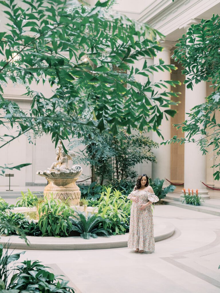 Pregnant Mother Stands In Atrium Of National Gallery Of Art During Her Maternity Session.