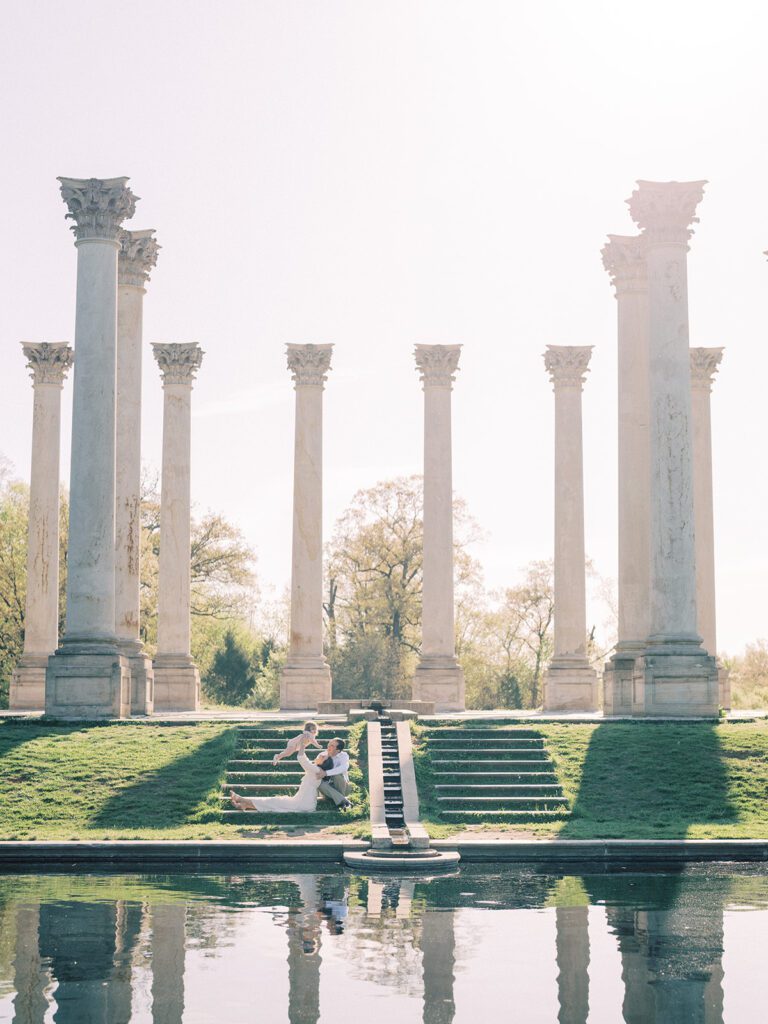 A family of three sits on the steps of the Capital Columns at the National Arboretum in DC, photographed by Bethesda Photographer Marie Elizabeth Photography.