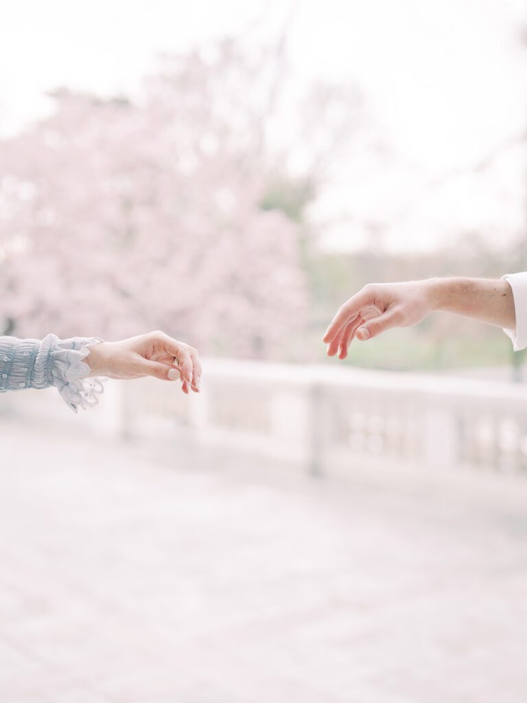 Two Hands Reaching For Each Other On A Balcony.