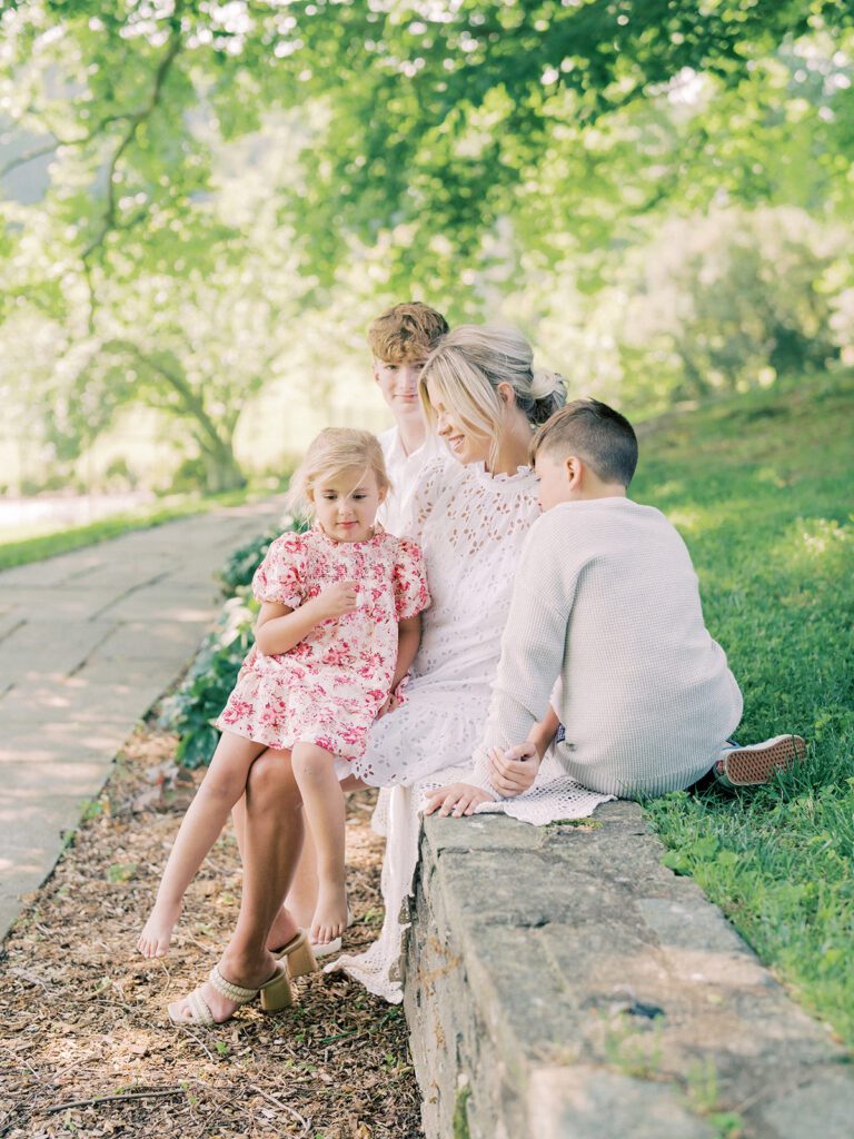 Mother sits with her three children on a stone wall at Glenview Mansion MD.