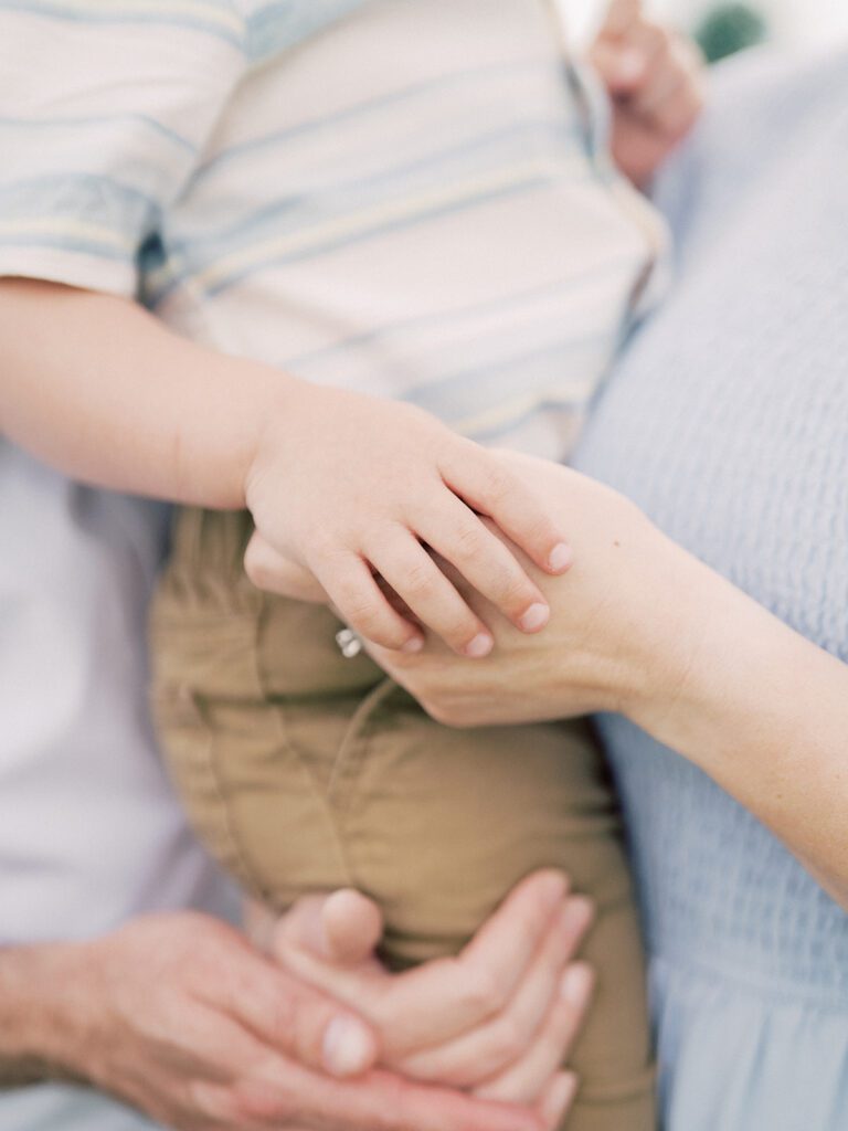 Close-Up View Of A Little Boy Holding His Mother's Hand.