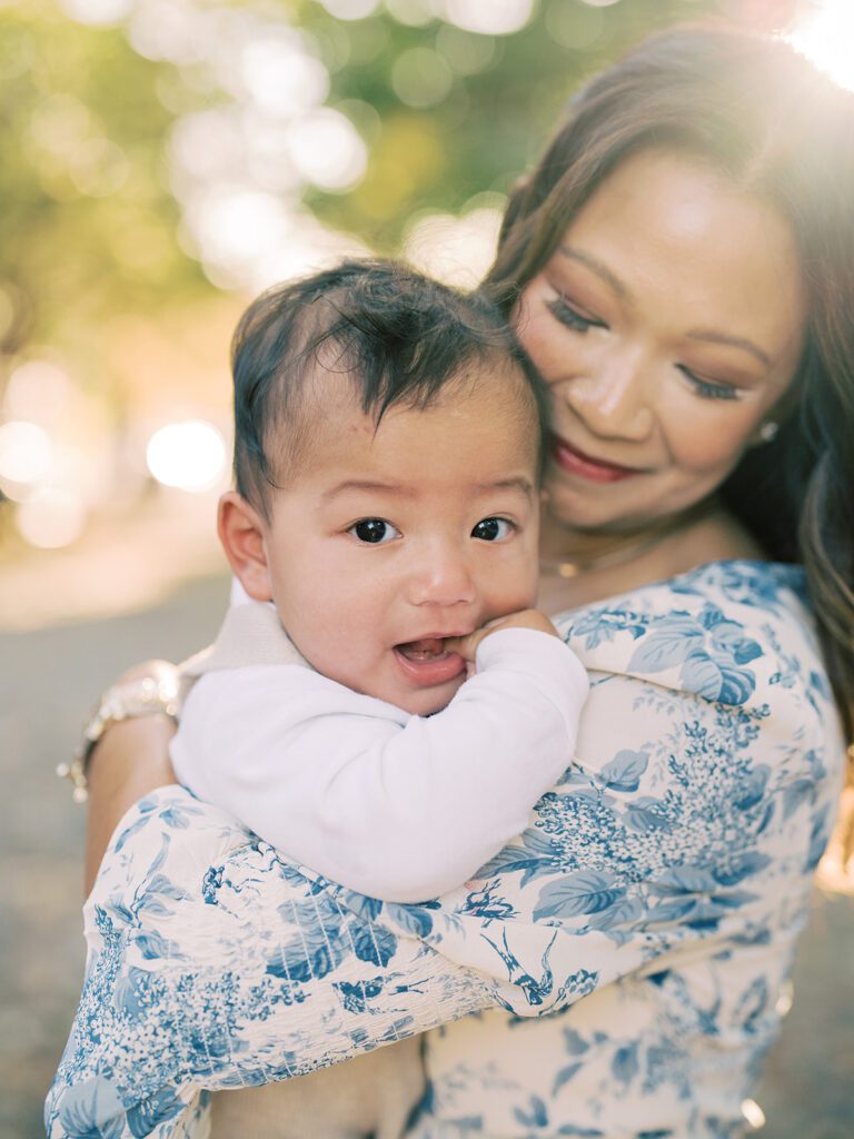 Close-up view of a baby boy held by his mother during sunrise in Alexandria, VA.