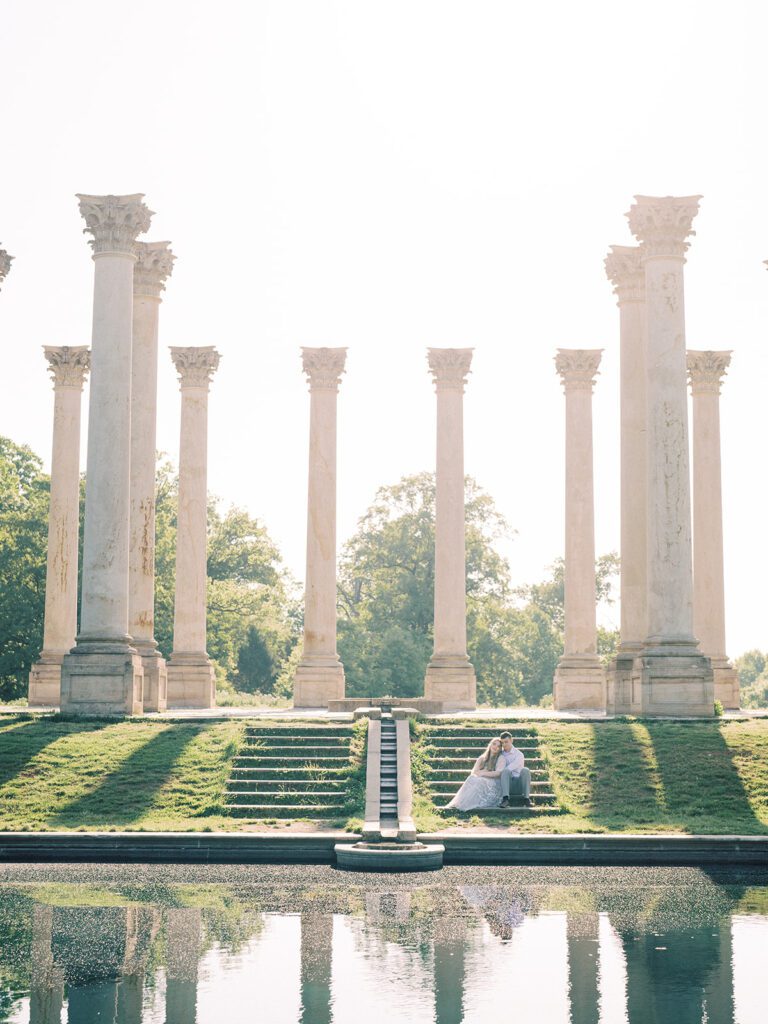 Pulled Back View Of A Couple Sitting On The Steps Of The Capital Columns At The National Arboretum.