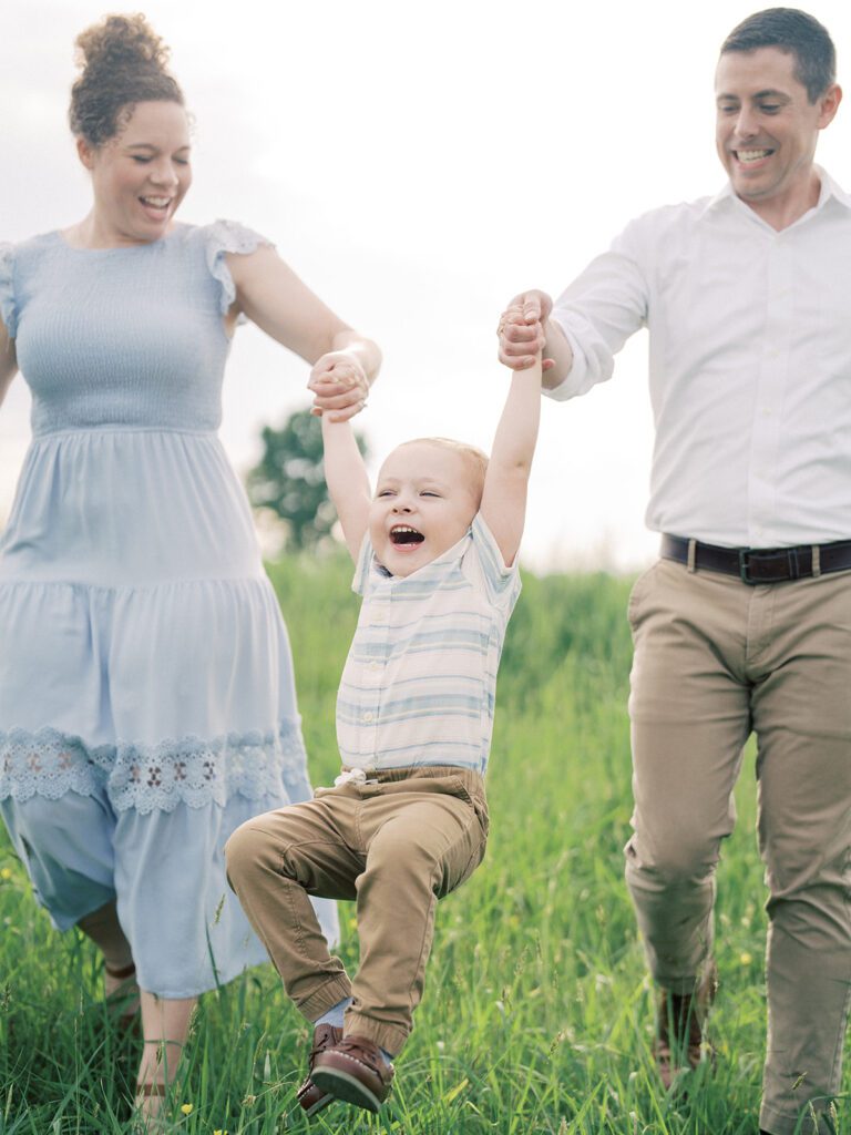 Little Boy Is Swung By His Parents As They Walk Through Manassas Battlefield.