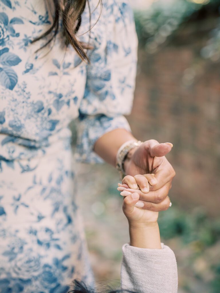 Close-up view of a mother holding her son's hand.