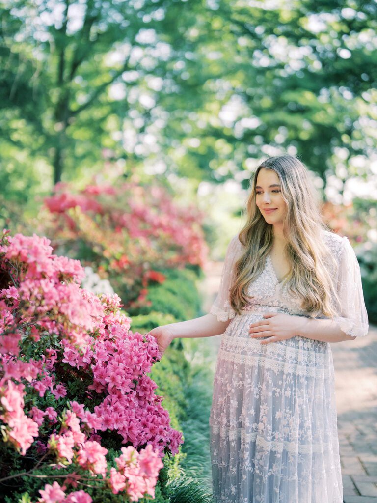 Pregnant Mother Stands In Garden Of Pink Azaleas During Her National Arboretum Azaleas Maternity Session.