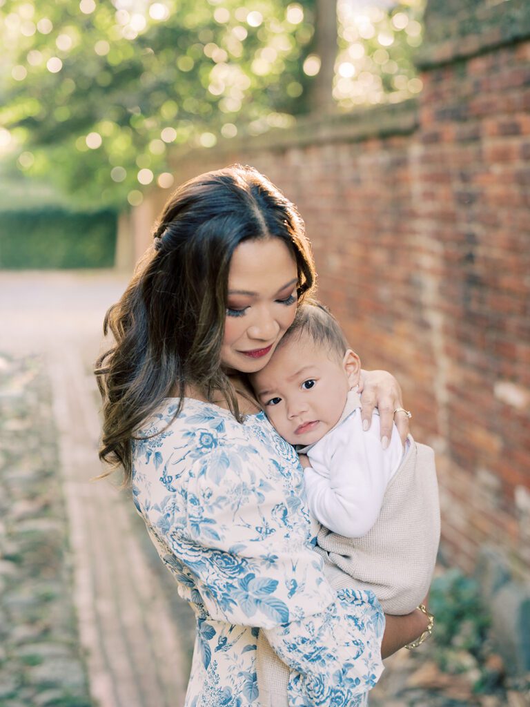 A mother holds her baby boy close to her while standing in an alley photographed by Alexandria Photographer, Marie Elizabeth Photography.