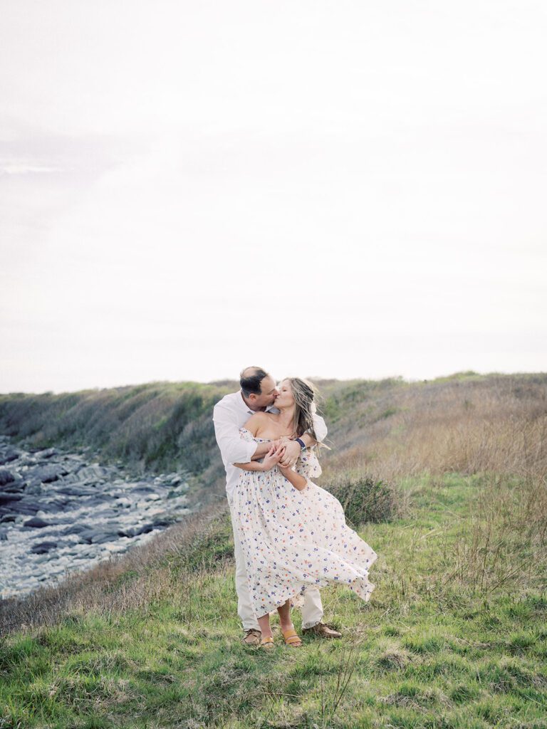 A Man And Woman Kiss Along The Rhode Island Coastline, Photographed By Destination Family Photographer, Marie Elizabeth Photography.