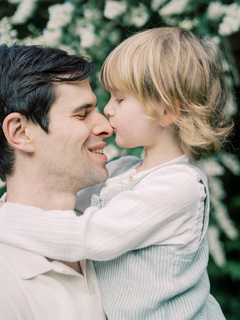 A Blonde Boy Kisses His Dad's Nose.