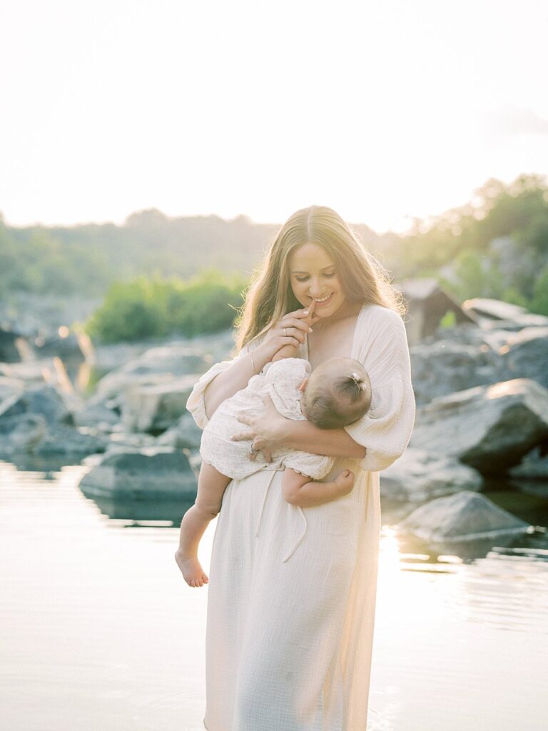 A Mother Nurses Her One Year Old Daughter As She Stands Amongst The Water During Their Great Falls Park Photos.