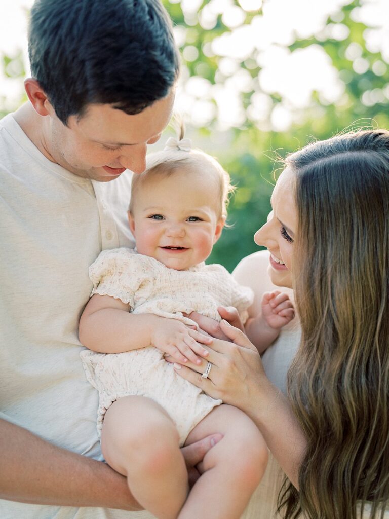 Parents Hold Their One Year Old Daughter In Between Them During The Family Photos In Great Falls.