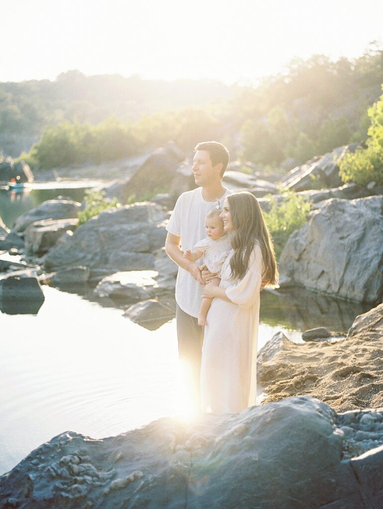 A Mother, Father, And One Year Old Daughter Stand Along The Water During Their Great Falls Park Photos.