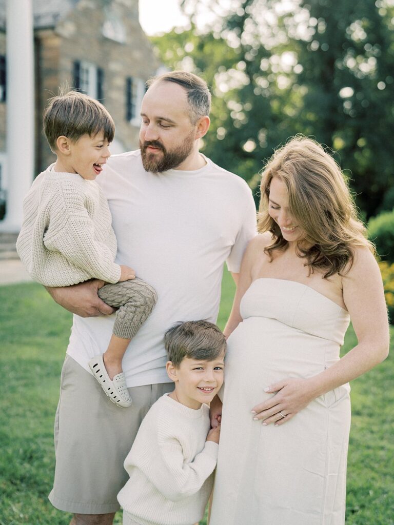 A Mother And Father Stand With Their Two Young Boys At Glenview Manor, Photographed By One Of The Best Rockville Md Family Photographers, Marie Elizabeth Photography. 