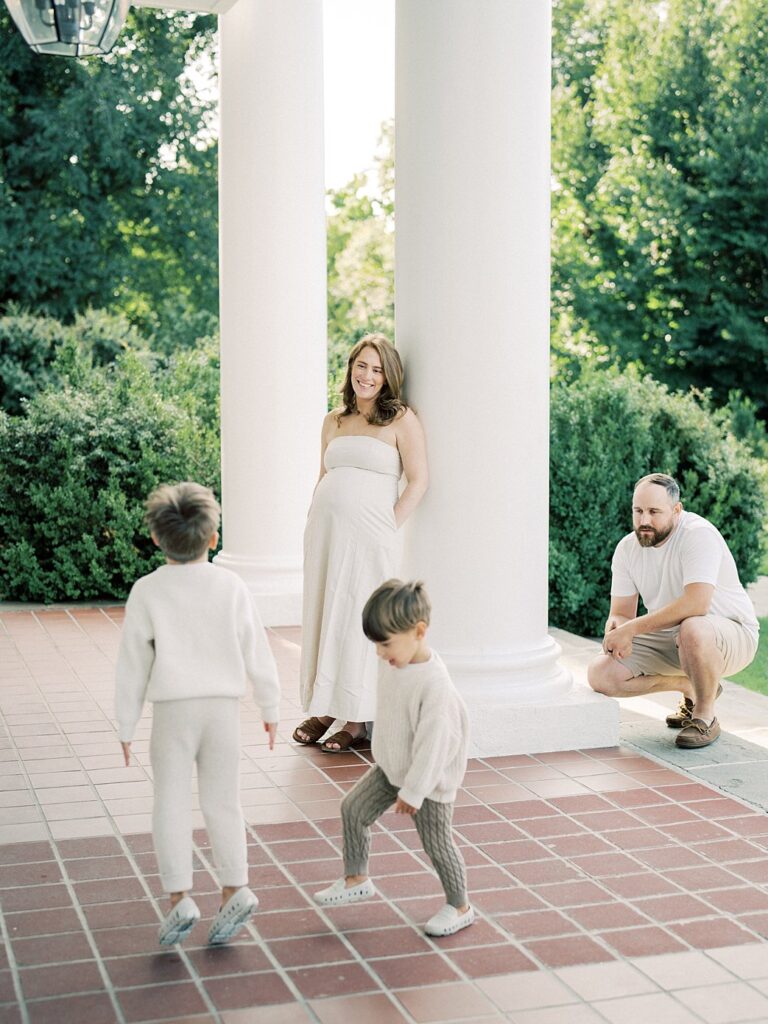 Two Little Boys Play On The Portico Of Glenview Mansion While Their Parents Watch Them.