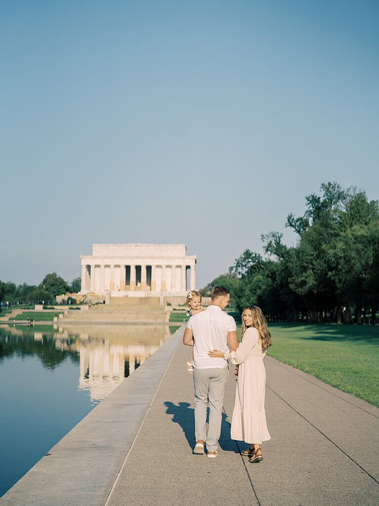 A Couple Walk Towards The Lincoln Memorial During Their Family Photo Session In Dc.