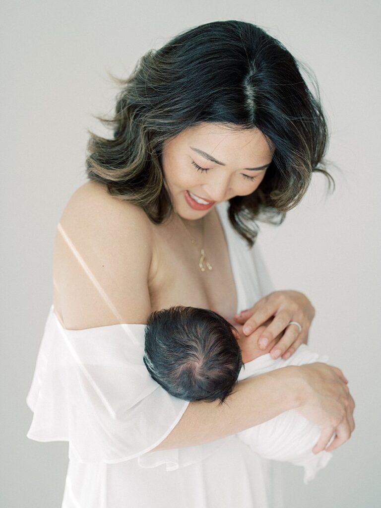 A Mother Nurses Her Newborn Baby During Her Falls Church Newborn Photography Session.