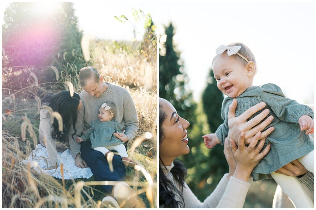 A Baby Girl In A Sage Green Dress Is With Her Mother And Father At A Christmas Tree Farm.