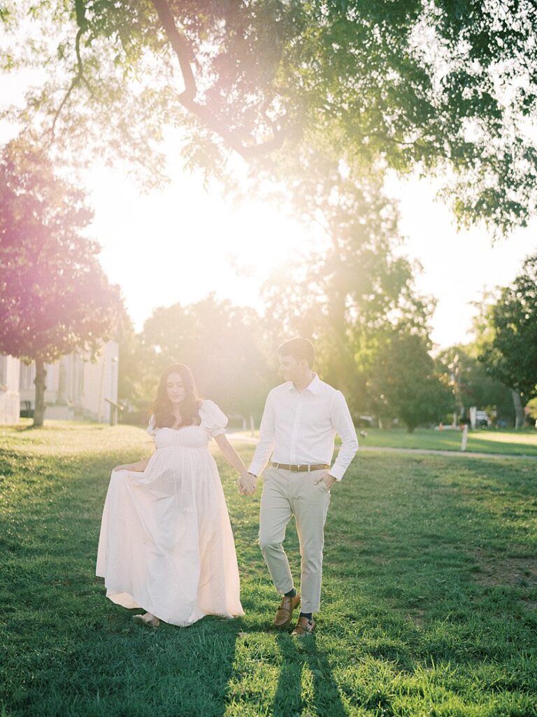 Couple Walk Together At Sunset During Their Maternity Session.